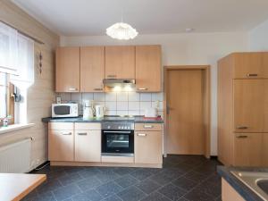 a kitchen with a stove and a microwave at Cozy Ski Base with Garden in Breitenbrunn