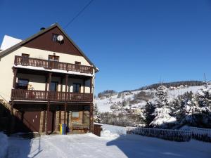 a house with a balcony and a snow covered yard at Cozy Ski Base with Garden in Breitenbrunn +36 photos