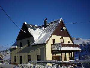 a house with snow on the roof of it at Cozy Ski Base with Garden in Breitenbrunn