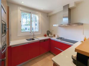 a kitchen with red cabinets and a window at Sunny Terrace Near Beach in L'Escala