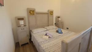 een slaapkamer met een bed met twee kussens erop bij La casa di Rubin in Carloforte