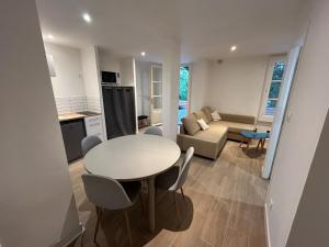 a kitchen and living room with a table and a couch at Les Châtaigniers in Villeneuvette