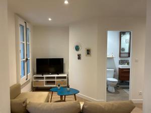 a living room with a couch and a tv at Les Châtaigniers in Villeneuvette