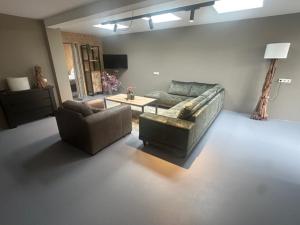 a living room with two couches and a table at Natuurlodge XXL in Blesdijke
