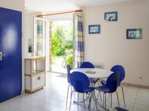 una sala da pranzo con un tavolo e sedie blu di Semi-detached houses, Etables-sur-Mer a Gicquel