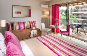 a living room with a couch and a table at The Originals Boutique, Hôtel Les Strélitzias in Juan-les-Pins