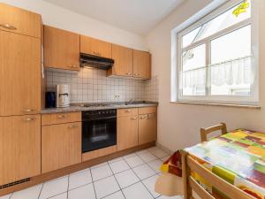 a kitchen with wooden cabinets and a table and a window at Moselle Charm in Ediger-Eller in Sankt Aldegund