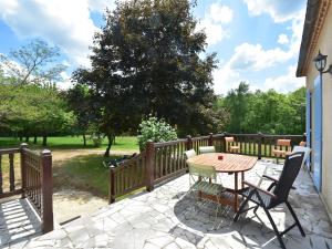 a patio with a table and chairs and a tree at Labardamier Garden Home in Villefranche-du-Périgord