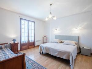 a white bedroom with two beds and a window at Labardamier Garden Home in Villefranche-du-Périgord