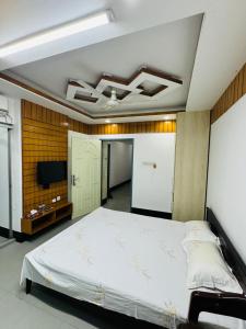 ein Schlafzimmer mit einem großen Bett und einem Flachbildfernseher in der Unterkunft taman hotel in Bāipāil