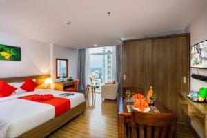a hotel room with a bed and a desk and a table at Maple Leaf Hotel & Apartment in Nha Trang
