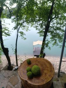 a wooden table with three kiwi fruits on it at House Maclura Jablanica Lake in Železnička Stanica Ostrožac +18 photos