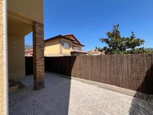 a house with a brick fence and a building at Casa Sol y Valle in Sotillo de la Adrada