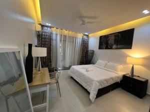 a bedroom with a bed and a desk and a television at softlife home vale in Nyali +19 photos