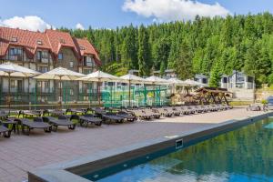a resort with tables and chairs next to a pool at Continental SPA Resort in Bukovel +150 photos
