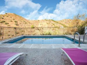 una piscina con una valla y una montaña en Sunny Solarium Holiday Home, en Málaga