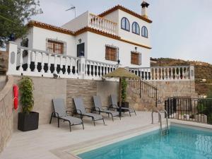 una villa con piscina frente a una casa en Sunny Solarium Holiday Home, en Málaga