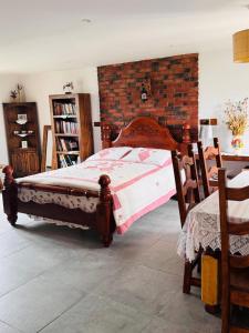 a bedroom with a wooden bed and a brick wall at Peaceful countryside retreat in Gedney Hill