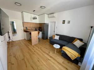 a living room with a couch and a kitchen at Mirno in elegantno stanovanje - Parkirišče, Netflix, wifi in Maribor