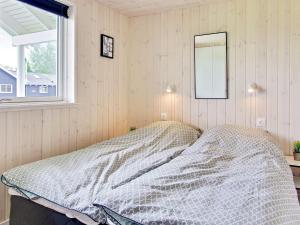 a bed in a room with a mirror and a window at 5 star holiday home in Kappeln in Kappeln
