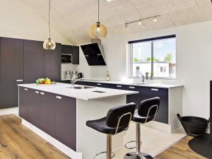 a kitchen with black and white cabinets and bar stools at 5 star holiday home in Kappeln in Kappeln