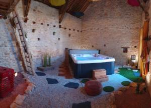 Habitación grande con bañera en una pared de ladrillo. en La Chaume de Condé, en La Celle-Condé