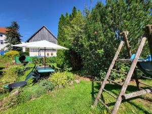 a garden with an umbrella and a table and chairs at Ferienwohnung in den Hüttenroder Bergen in Hüttenrode