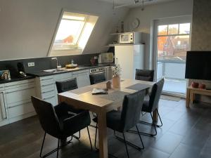 a kitchen with a wooden table and chairs in it at Skippersin2 in Greetsiel