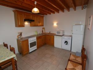 a kitchen with white appliances and wooden cabinets at Normandy Family Escape in Saint-Floxel +13 photos