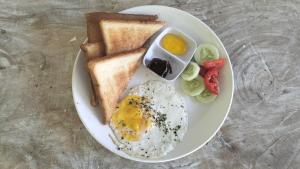 a plate of breakfast food with eggs toast and tomatoes at Serene Beach Villa in Gili Trawangan