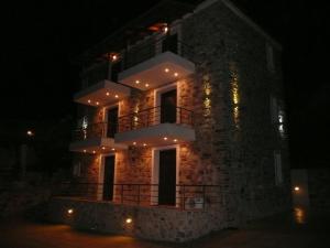 a brick building with a balcony at night at Labetia Apartments in Agioi Apostoli