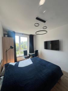 クラクフにあるLoft Apartmentの青い毛布が掛けられた大きなベッドのある寝室
