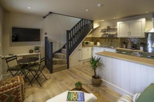 a kitchen and living room with a staircase and a table at The Mitre Inn in Glastonbury