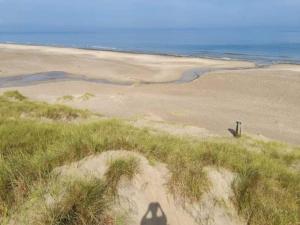 a shadow of a person standing on a beach at 6 person holiday home in Brovst in Brovst