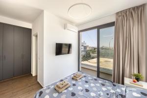 a bedroom with a bed and a large window at Seaside Emerald in Paralimni +86 photos