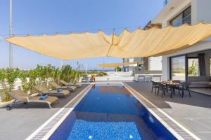 a house with a swimming pool and a patio at Seaside Emerald in Paralimni