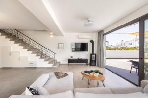 a living room with a white couch and a table at Seaside Emerald in Paralimni