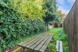 a wooden bench sitting in front of a fence at Terraced Taylor in Southborough