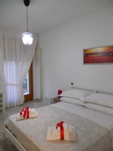 a bedroom with two beds with red bows on them at LA CASA di ROSA 