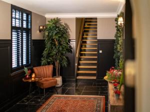 a hallway with a staircase and a chair and a rug at Beautiful holiday home in Vlaanderen with shared pool in Heissehuizen