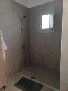 a bathroom with a shower with a window at Anastasakos villas in Mavrovouni +8 photos