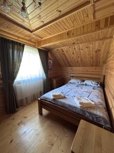 a bed in a room with a wooden ceiling at Смерековий двір in Slavske +14 photos
