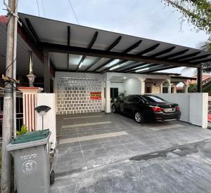 a garage with a car parked in front of a house at Homestay Taman Laksamana, Muar in Muar