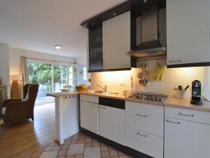 a kitchen with white cabinets and a counter top at Holiday Home Voorthuizen near De Veluwe in Voorthuizen
