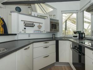 a kitchen with white cabinets and a microwave at 6 person holiday home in Oksbøl in Oksbøl