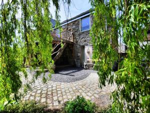 an exterior view of a stone house with a patio at Farmhouse in Durbuy with Sauna & Garden in Oppagne
