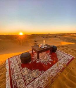 a table in the middle of a desert with tires on it at Merzouga Exclusive Camp in Merzouga