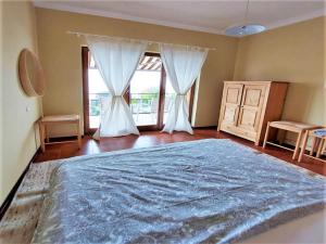 une chambre avec un grand lit et deux fenêtres dans l'établissement Belvilla by OYO PAN03 3 - Residenza Panorama, à Maccagno Inferiore