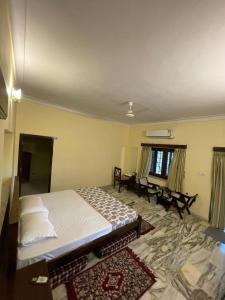 Un dormitorio con una cama y una mesa dentro. en Anandmai Heritage Villa Mount Abu, en Delmāra 20 fotos más