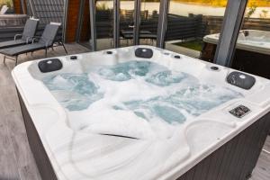 a jacuzzi tub with snow inside of a building at Cabane Masaya Aframe in Periş